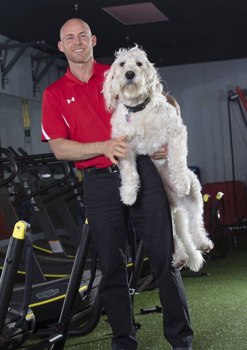 Nate Dixon, owner of LAVA 24 Fitness, holding his dog Duke